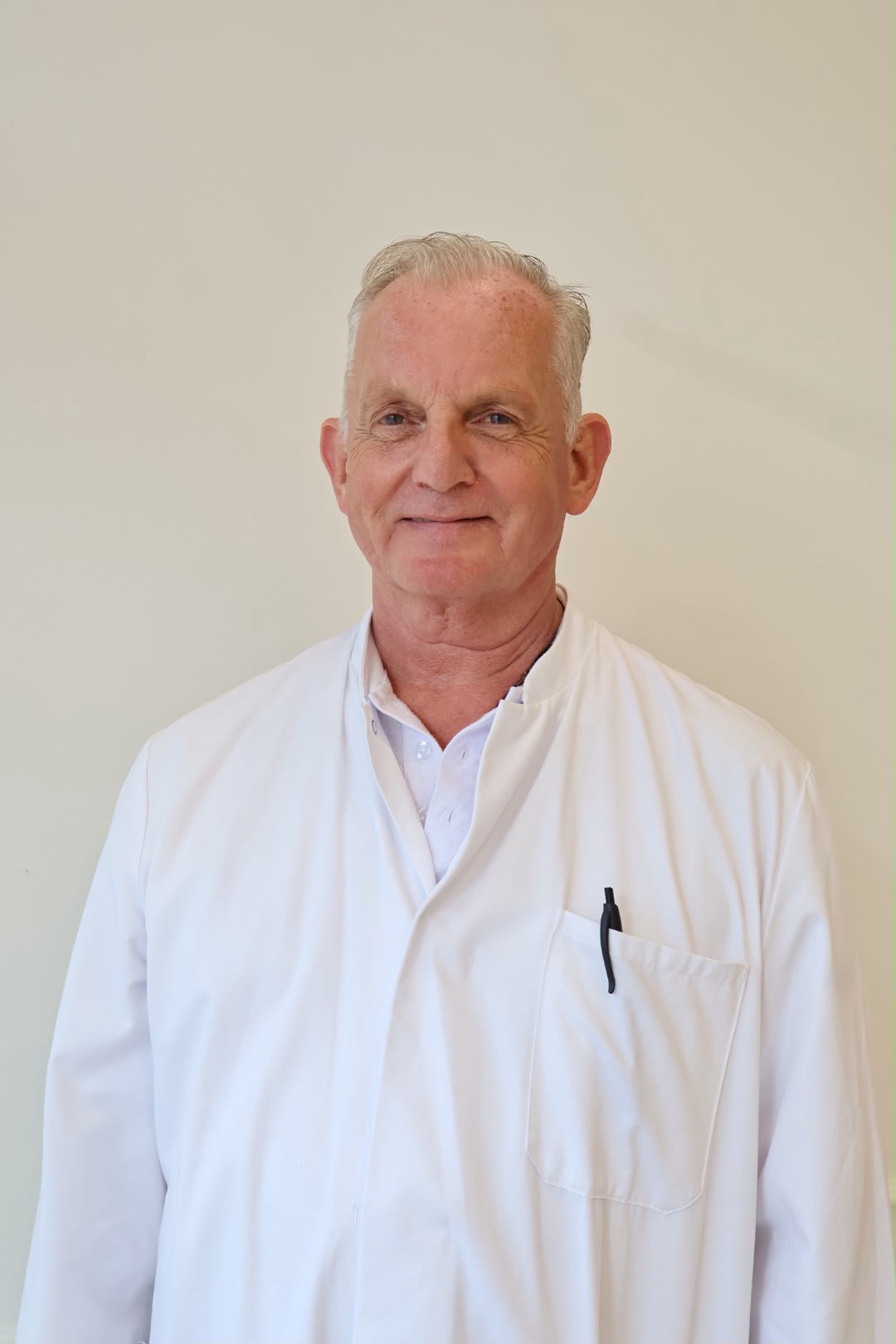 Dr. Manuel Joaquín in a white coat, smiling